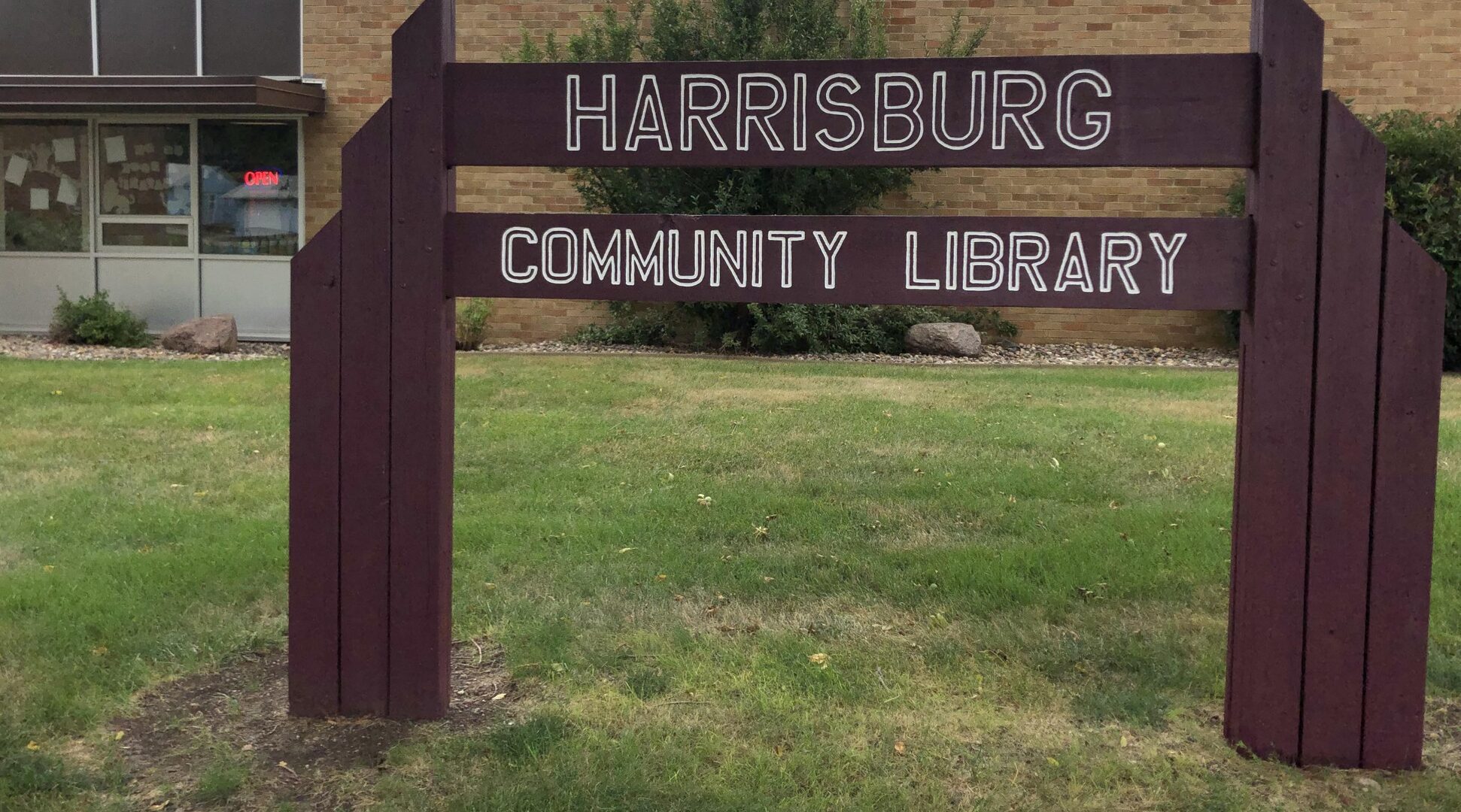 Sign that reads Harrisburg Community Library in front of library building.